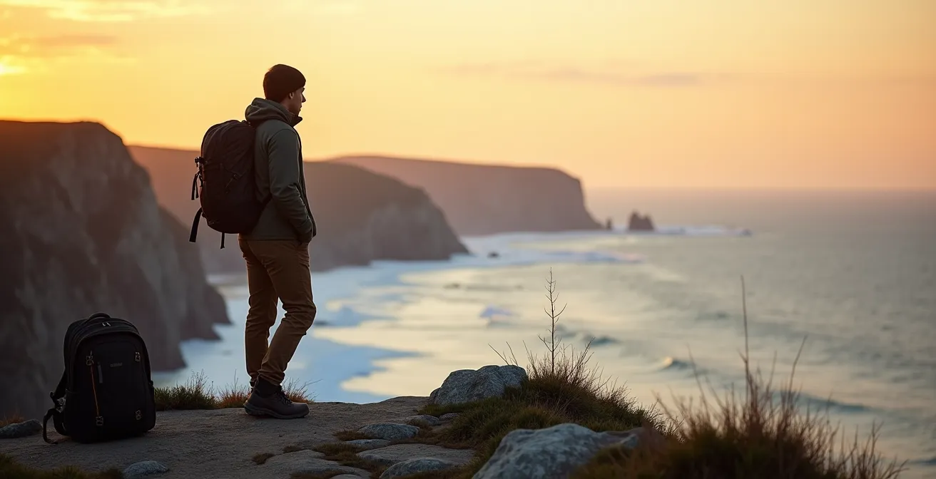 Randonneur solitaire contemplant le paysage gaspésien au coucher du soleil